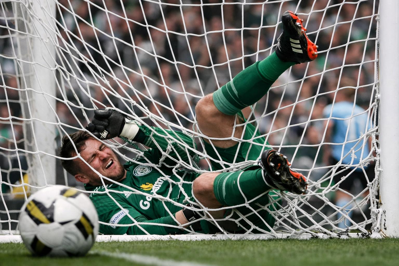 Celtic goalkeeper falling in the back of the net